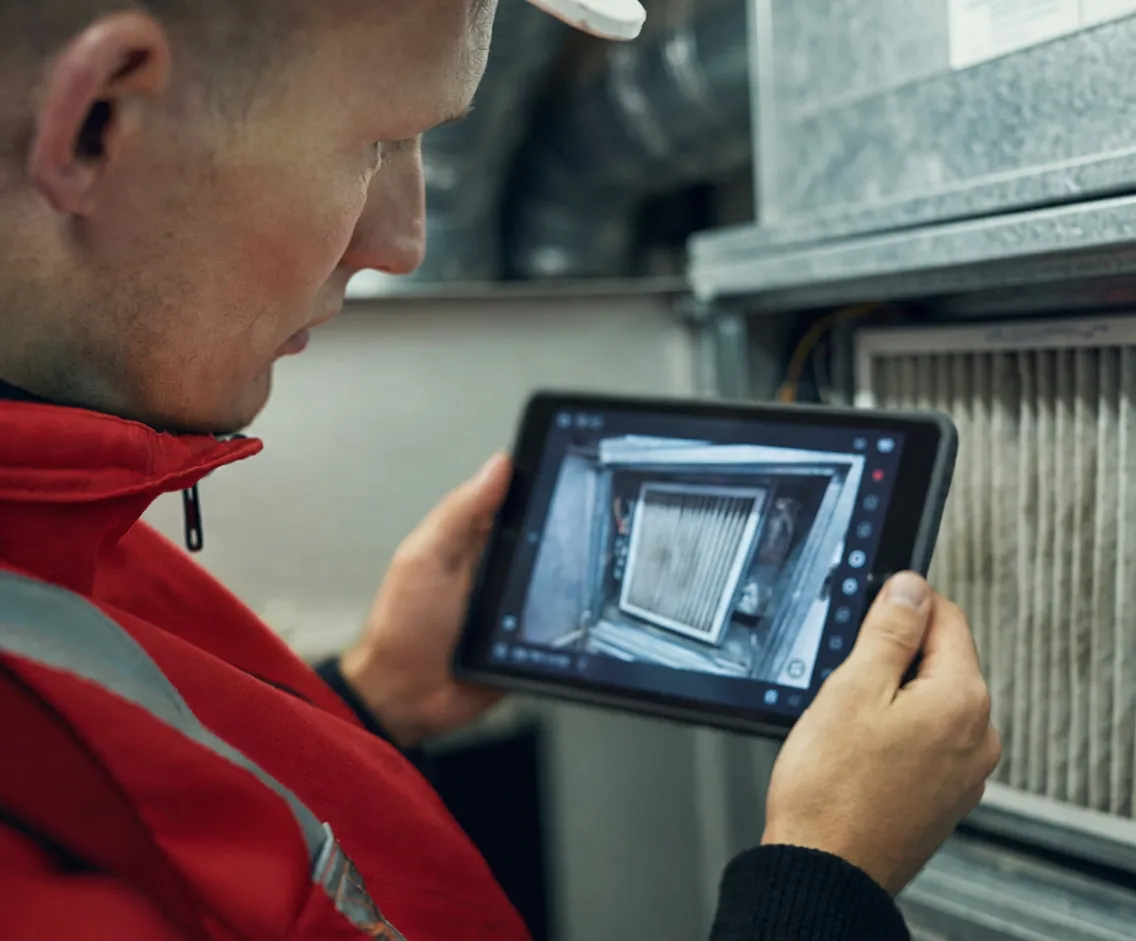 pro-documenting-hvac-filter A PRO documenting an HVAC filter with a tablet
