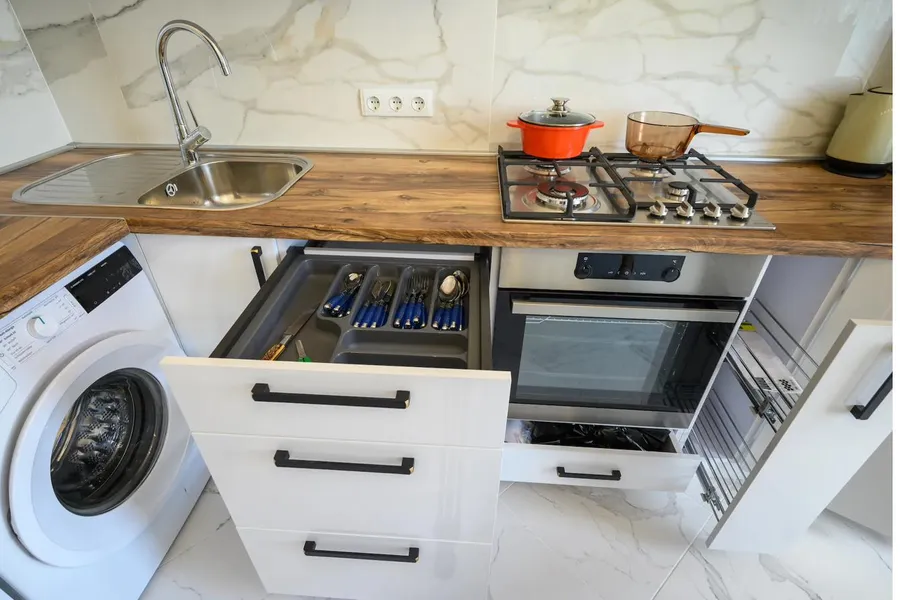 services-card-kitchens A kitchen with the oven, cooktop and an open drawer